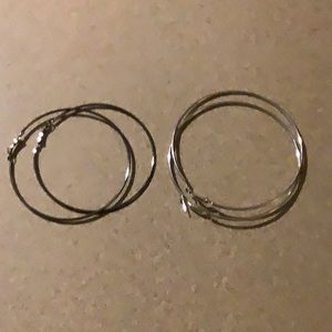 2 Pairs of large hoop earrings, one is silver toned, the other is darker brown